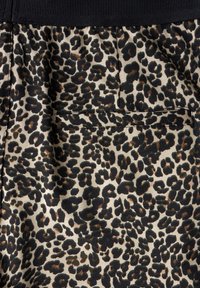 Leopard-print fabric with a beige background, featuring black and brown spots. Soft texture with a black elastic waistband and patch pocket.