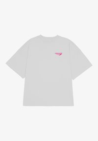 Lys grå oversized T-skjorte med korte ermer og rund hals. Har en liten rosa "PEGADOR" logo på venstre side. Myk stofftekstur.