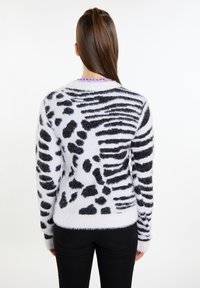 Zwart-wit fuzzy sweater met een dierenprintpatroon, met een gestructureerde afwerking en lange mouwen, afgebeeld vanaf de achterkant.