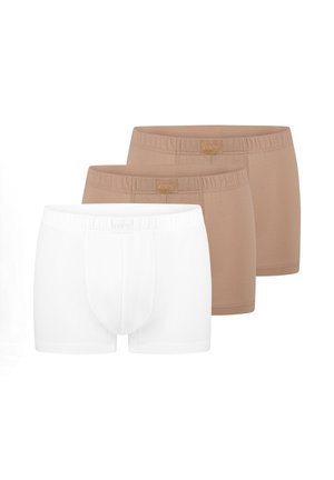Trzy pary męskich bokserek, dwie beżowe i jedna biała, ułożone w stos z elastycznymi pasami i delikatnymi przeszyciami z przodu.