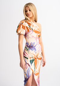 Abito off-the-shoulder in tessuto a fantasia floreale; presenta maniche a sbuffo, sfondo pastello, colori vivaci e spacco laterale.