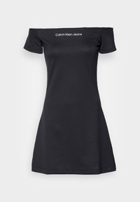 Svart axelbar klänning med korta ärmar och vit "Calvin Klein Jeans" logga centrerad på bröstet, uppvisad mot en enkel bakgrund.