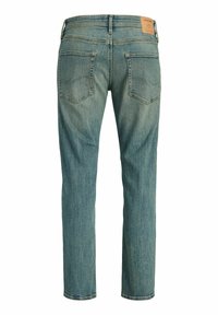 Helerohelised teksapüksid, millel on tagataskud ja pruun nahast brändiplaaster vöörihmil, vaadatuna tagant.