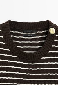 Maglione di cotone marrone con righe bianche. Presenta un colletto a coste e un dettaglio con bottone dorato. Etichetta visibile all'interno del colletto.