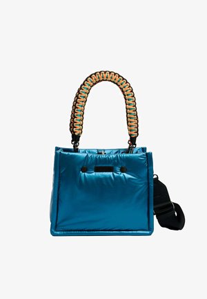 Blauwe gewatteerde draagtas met een gestructureerde vorm. Heeft een gevlochten handvat in meerdere kleuren en twee zwarte knopen aan de voorkant. Inclusief een afneembare schouderband.