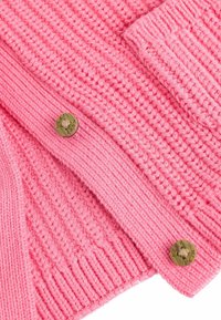 Knitted pink cardigan featuring a textured pattern, ribbed edges, and bronze button detailing. Soft, chunky material for warmth.
