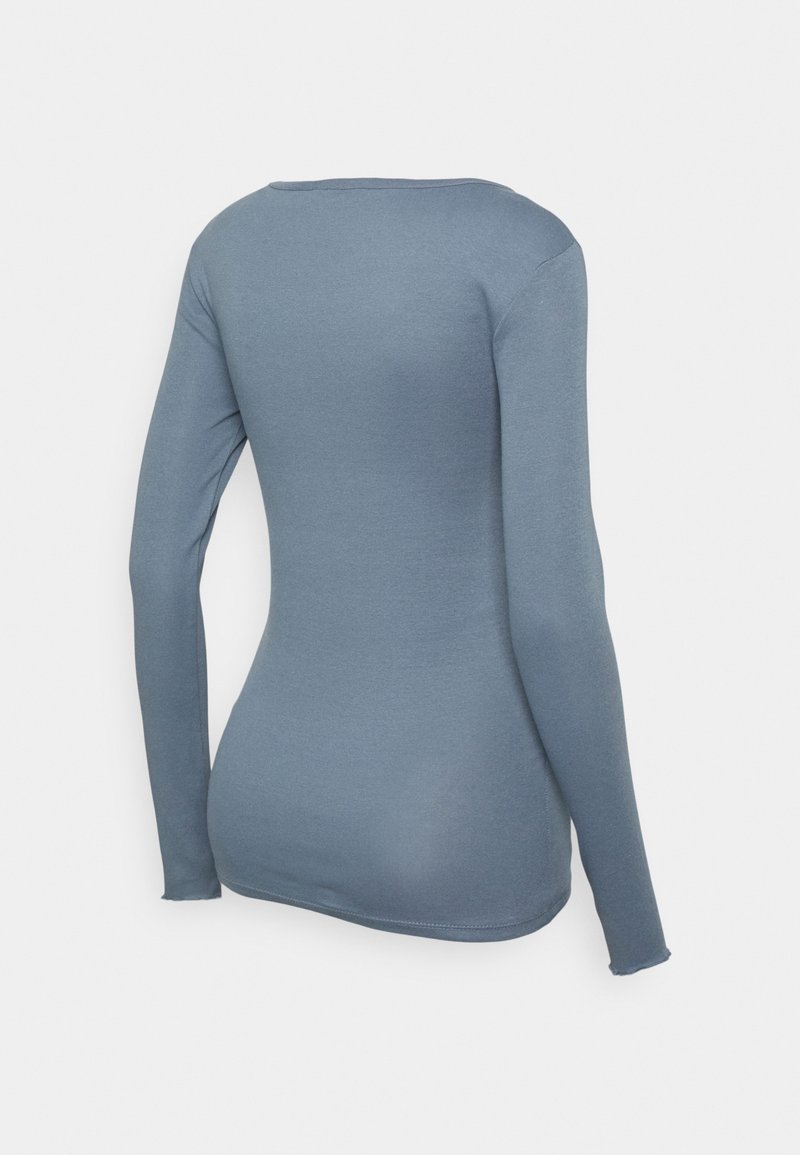 Camisola de manga longa azul, feita de um tecido suave e elástico. Apresenta um decote redondo e uma silhueta ajustada com costuras suaves.
