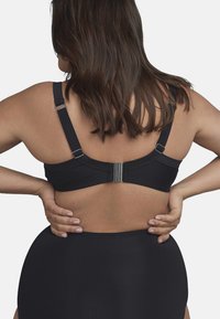Zwart beha met verstelbare bandjes en een haak- en oogsluiting. Glad, rekbaar stof omlijnt de rug en zijkanten, met een minimalistisch ontwerp.