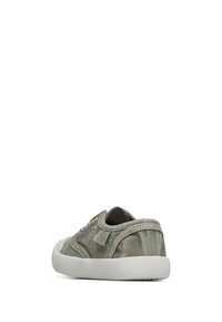 Green canvas sneaker with white rubber sole, viewed from the back left side, showing stitching and fabric texture.