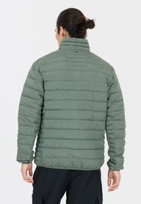 Polstret jakke i olivengrøn, med horisontalt quiltet design, høj krave og elastiske manchetter, lavet af let materiale.