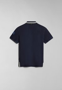 Námořnická modrá polo tričko s krátkými rukávy, bílým límečkem a strukturovanou tkaninou; má malý pruhovaný akcent na levém rukávu.