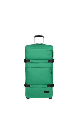 Valise verte à roulettes avec poignée extensible, deux sangles de compression noires, poches avant zippées et logo Eastpak sur le panneau inférieur avant.