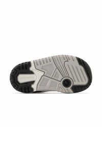 Podešev obuvi New Balance, s odolným černým gumovým povrchem, texturovanými bílými drážkami a výrazným brandingem na boku.