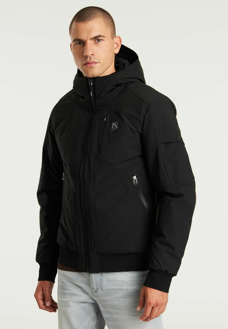 Czarna kurtka z kapturem, wykonana z gładkiego, odpornego na warunki atmosferyczne materiału. Posiada kieszenie zapinane na suwak, ściągacze na mankietach oraz dopasowany krój.