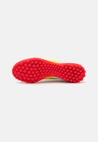 Suela de goma roja con un patrón hexagonal, con un diseño superior en amarillo y blanco. Construcción ligera y elegante para mayor agilidad.