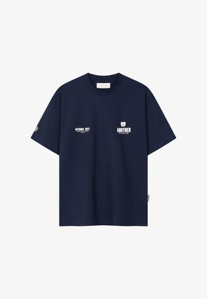 T-shirt bleu marine à manches courtes en coton avec logos textuels blancs "OUTDOOR DEPT." et "ANOTHER COTTON LAB" sur la poitrine avant.