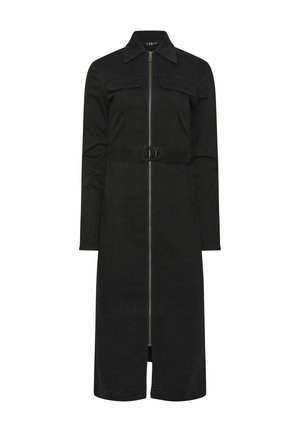 Lange zwarte jurk met rits en kraag, lange mouwen, borstzakken en een riem met een ronde gesp in de taille.