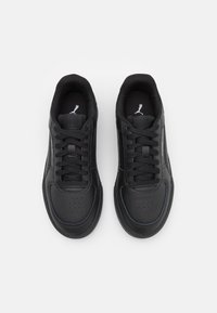 Mustad mustad sneakers sileda nahast pealispinnaga, millel on pokkerige detailid, lame paelad ja diskreetne logo keeles. Kummist tald.