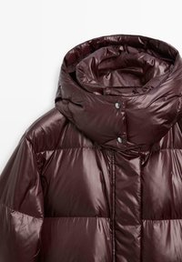 Hoogglans donker bordeaux pufferjack met een gevoerde hoge kraag en drukknopen.