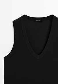 Top senza maniche nero con design a profondo scollo a V, texture a coste e bordi cuciti. Etichetta con la scritta "Massimo Dutti", prodotto in Marocco.