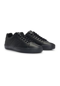 Zwarte leren sneakers met een gestructureerde zijpanelen, ronde neus en dikke rubberen zool. Voorzien van zwarte veters en metalen oogjes.
