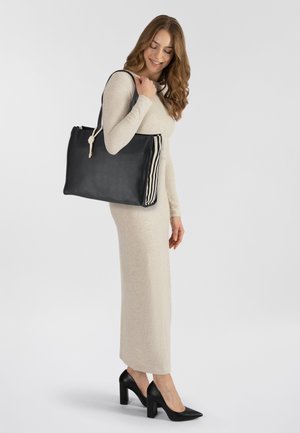 Borsa tote in pelle nera con lati in tessuto a righe e dettaglio in corda annodata, caratterizzata da un design rettangolare spazioso e robuste tracolle.