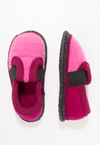 Vilt slippers in roze en donker magenta met elastische zijkanten en zwarte rubberen zolen. Rondom gevormd met contrasterende stikdetails.