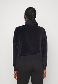 Maglione a collo alto navy in morbido tessuto testurizzato con polsini a costine. Caratterizzato da una vestibilità rilassata e un colore uniforme senza fantasie.