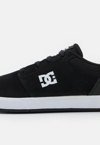 Scarpe da skate nere realizzate in morbido materiale suede e tessuto, con logo bianco, suola a contrasto, punta arrotondata e design a profilo basso.