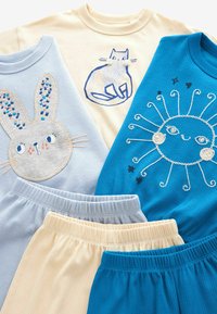 Quattro T-shirt con ricami a tema animale: un coniglio, un gatto e un sole. L'insieme include pantaloni corti abbinati nei colori blu e beige.