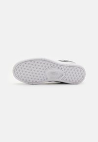 Fehér sneaker talp, textúrált gumival, hatszögletű mintázattal és hangsúlyos profillal. A középen látható a „VANS” logó.