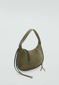 Sac à main en daim vert olive avec une silhouette incurvée, une poignée courte et deux sangles pendantes. Dispose d'une fermeture éclair sur le bord supérieur.
