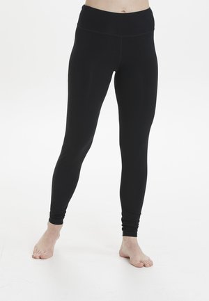 Mustat legginssit, jotka on valmistettu venyvästä kankaasta, korkea vyötärö, sileä pinta ja mukautuva muotoilu. Ei näkyviä kuvioita tai varusteita.