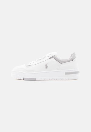 Biały niskoprofilowy sneaker z szarymi akcentami, sznurowaniem z przodu, amortyzowaną podeszwą i małym wyszywanym logo po boku.