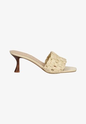 Sandalo mule con tacco beige con ampia fascia intrecciata e tacco basso in legno curvato su sfondo bianco.