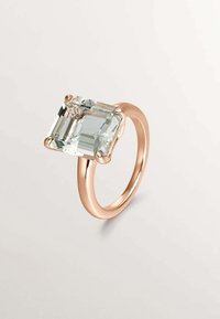 Anillo de oro rosa con una gran gema rectangular de color azul claro con facetas, colocada en un diseño de cuatro garras, banda suave y acabado pulido.
