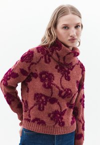 Strick-Turtleneck-Pullover in Rostrot mit dunkelpinkem Blumenmuster, geripptem Saum und Bündchen, weichem Material, lockerer Passform und leicht übergroßem Design.