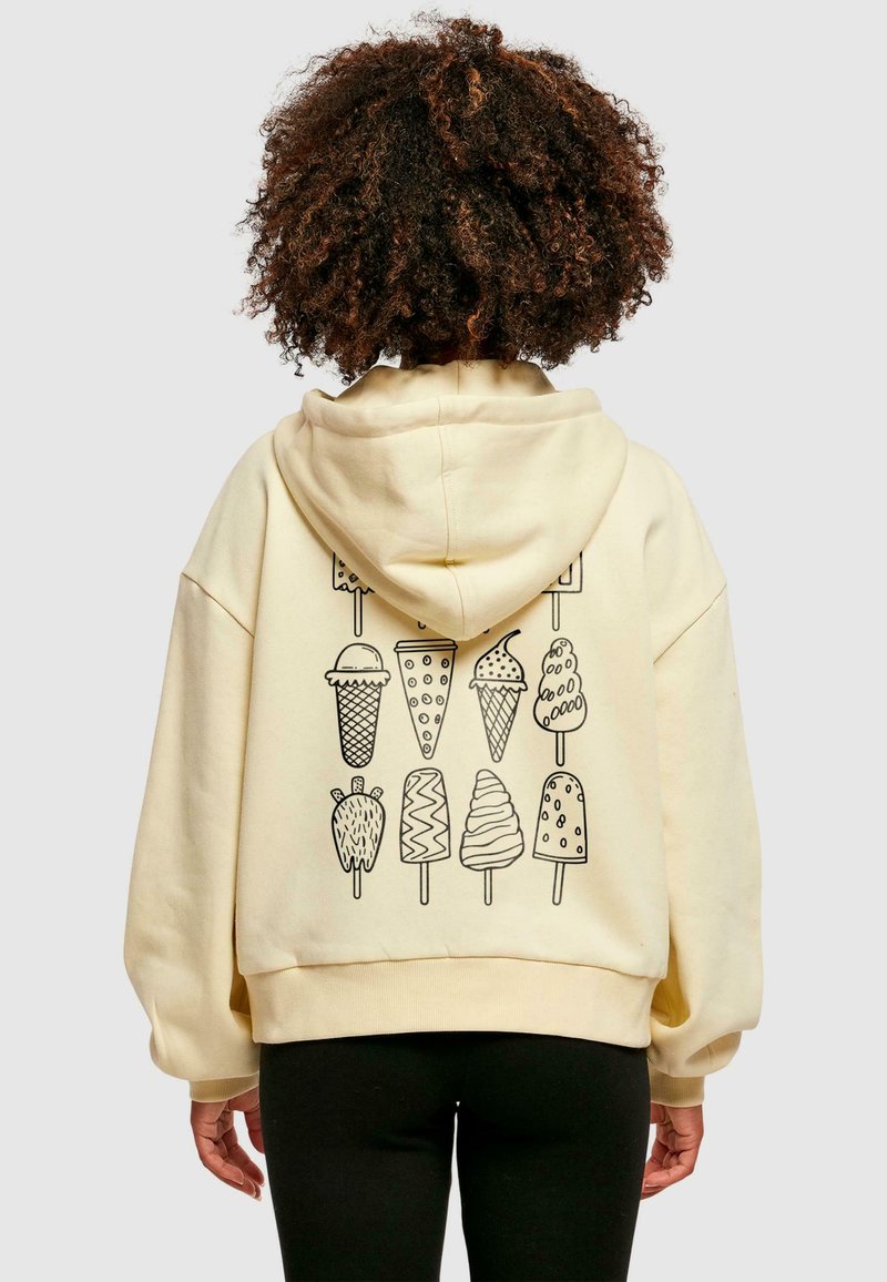 Kremowy hoodie z dużą grafiką różnych przysmaków lodowych w czarnym konturze na plecach. Oferuje luźny krój oraz kaptur ze sznurkiem.