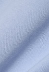 Tela azul clara con una textura fina acanalada, mostrando pliegues sutiles y una apariencia suave y lisa.