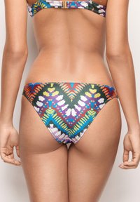 Bikini dolne z żywymi, wielokolorowymi wzorami geometrycznymi na teksturowanej tkaninie. Wycięte w niskim fasonie z umiarkowanym zakryciem.
