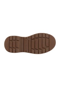 Brun gummisål med dybe udskæringer, rektangulære og chevron mønstre, samt mærkenavnet "Tom Tailor" præget i midten.