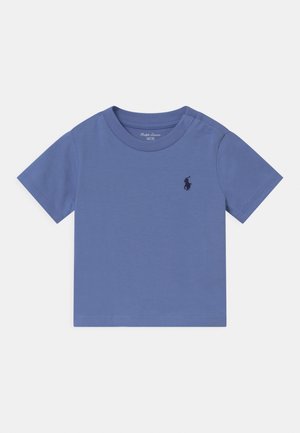 Babyblauw katoenen T-shirt met korte mouwen, drukknoopjes op de linkerschouder en een klein donker logo op de borst.