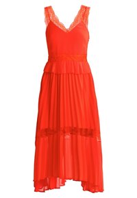 Robe plissée rouge avec des accents en dentelle, dotée d'un col en V et de fines bretelles. L'ourlet est plus court à l'avant et plus long à l'arrière.