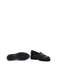 Mocasines de cuero negro con un diseño de flecos texturizados, que cuentan con una suela de goma gruesa y un tacón bajo para mayor durabilidad y agarre.