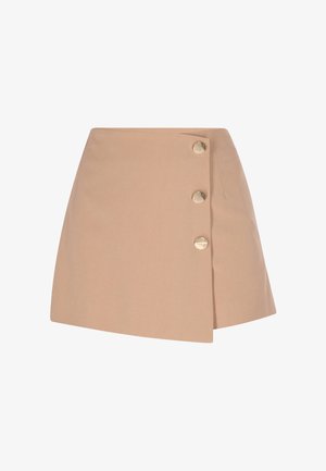 Mini-jupe asymétrique beige avec trois grands boutons dorés sur le côté droit, sur fond blanc.