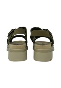 Infradito verde oliva con doppie cinghie regolabili, tomaia in ecopelle testurizzata e suola piatta beige, dotate di una soletta imbottita.