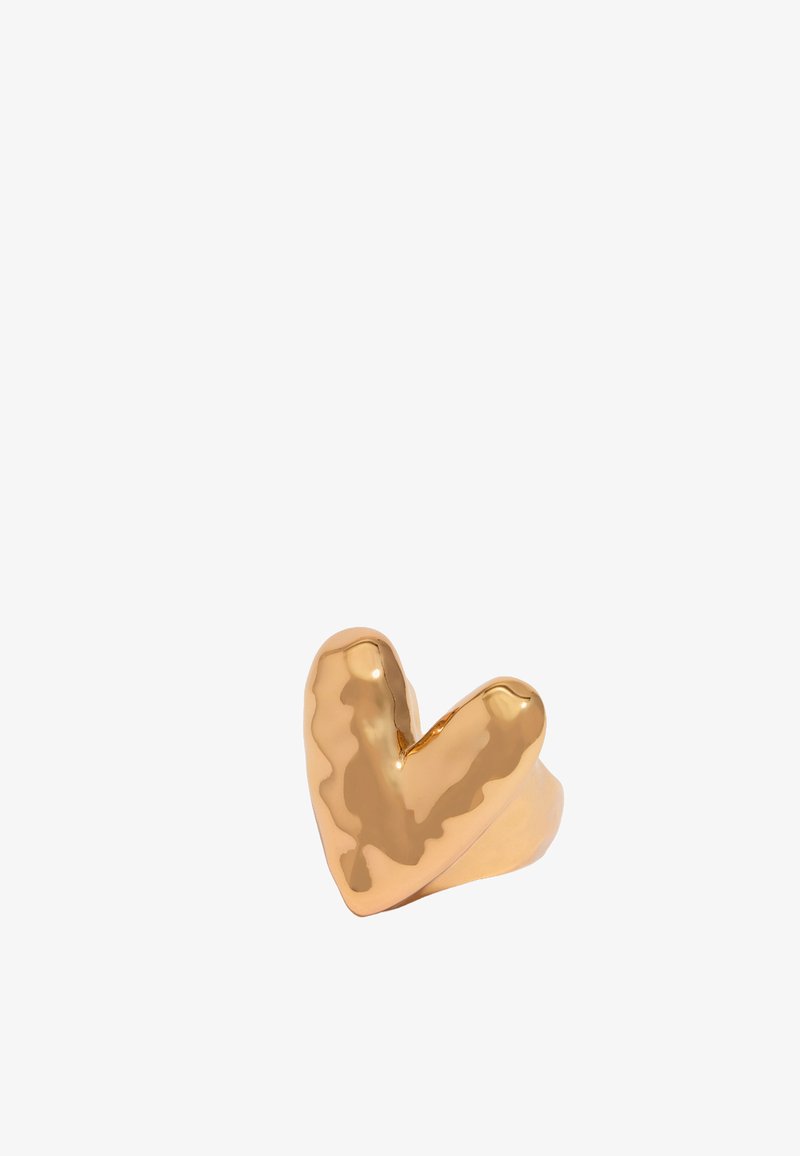 Gouden hartvormige ring met een gladde, gepolijste oppervlakte en een licht onregelmatige textuur. Eenvoudig bandontwerp complementeert de vorm.