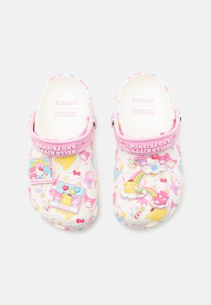Λευκά Crocs με ροζ λουράκια που διαθέτουν σχέδια Hello Kitty και φίλων, διακοσμημένα με πολύχρωμα καρτούν γούρια και ουράνια τόξα.