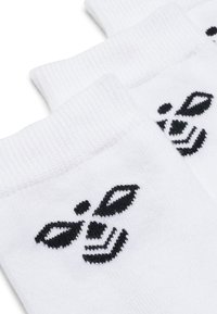 Hvide bomuldsstrømper med et sort broderet bi-design på ankelområdet, ribbede kanter og en glat tekstur.