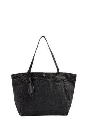 Czarna torba typu tote z denimu z dwoma paskami na ramię, zapięciem na guzik oraz ozdobną zawieszką na białym tle.
